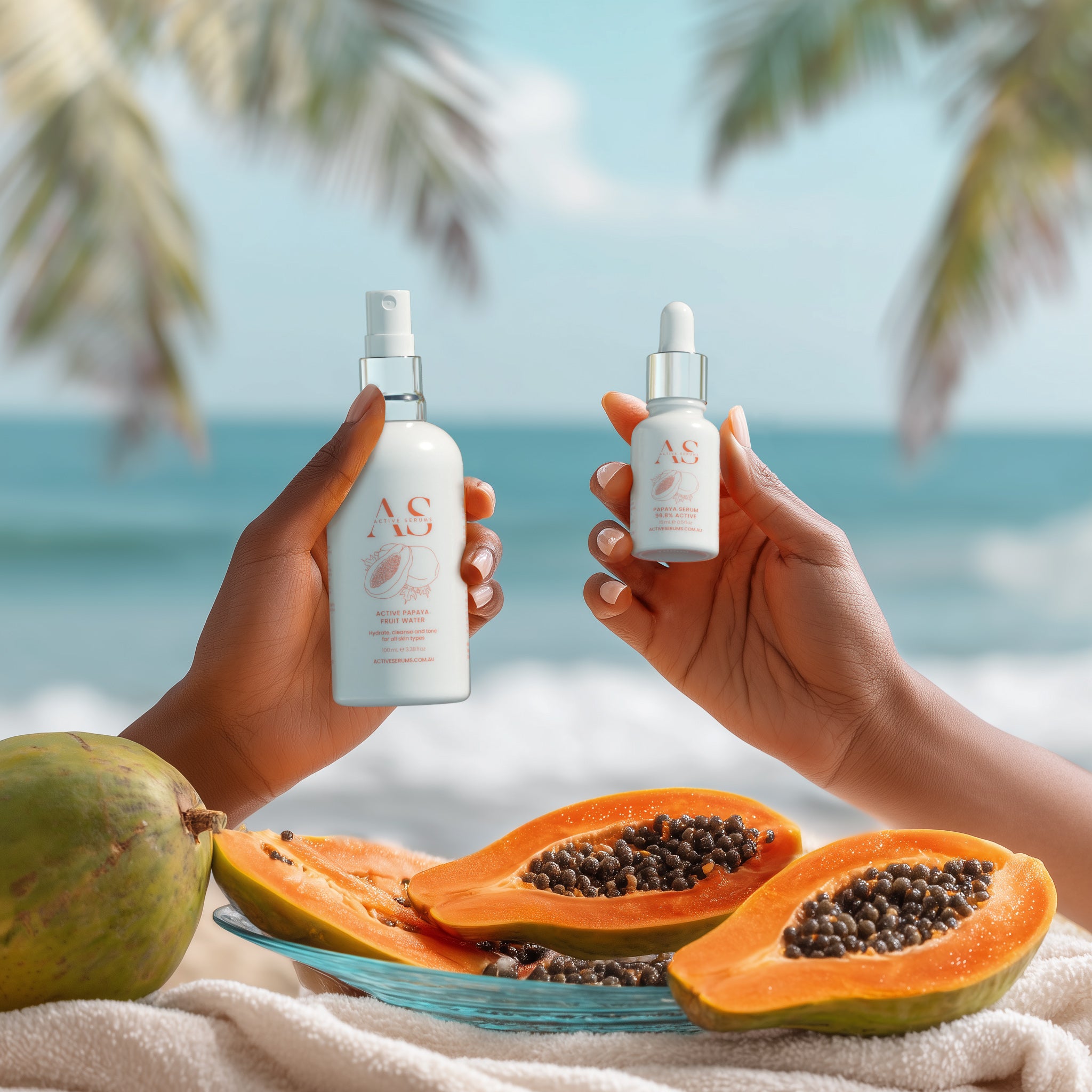 Hands holding Active Papaya Duo skincare products by the beach with fresh papaya fruit on a towel.