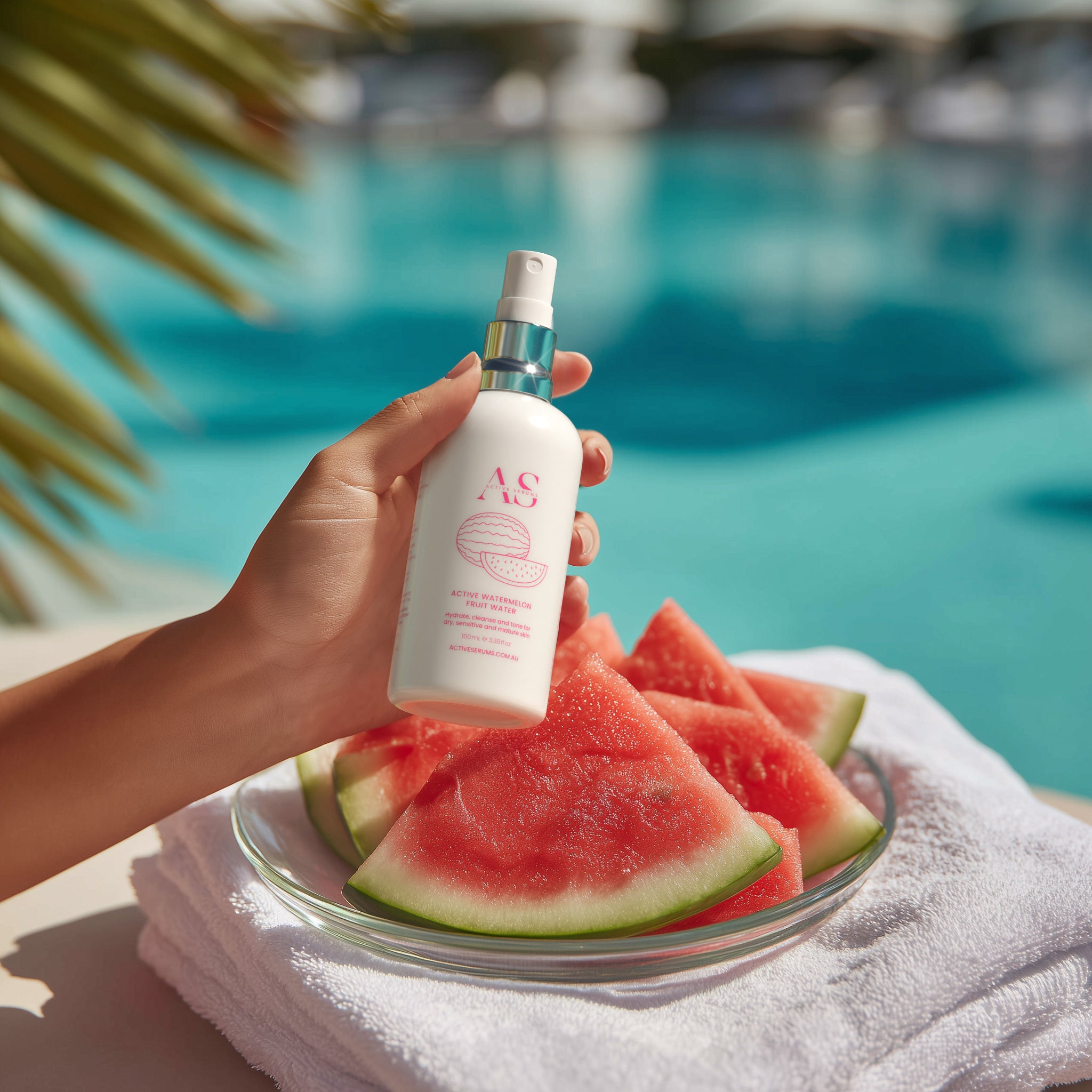Active Watermelon Fruit Water held in hand next to a tropical swimming pool with fresh watermelon slices.