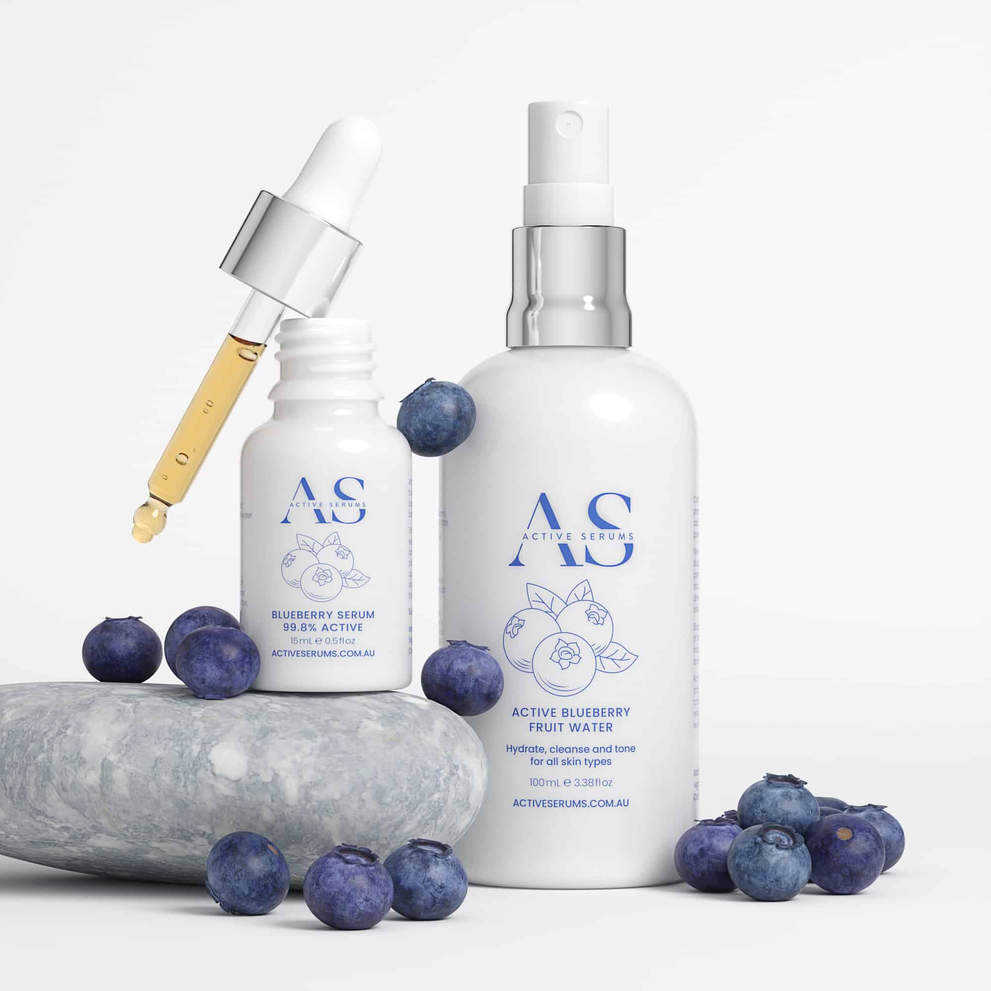 Active Serums blueberry serum and fruit water with fresh blueberries on a stone display