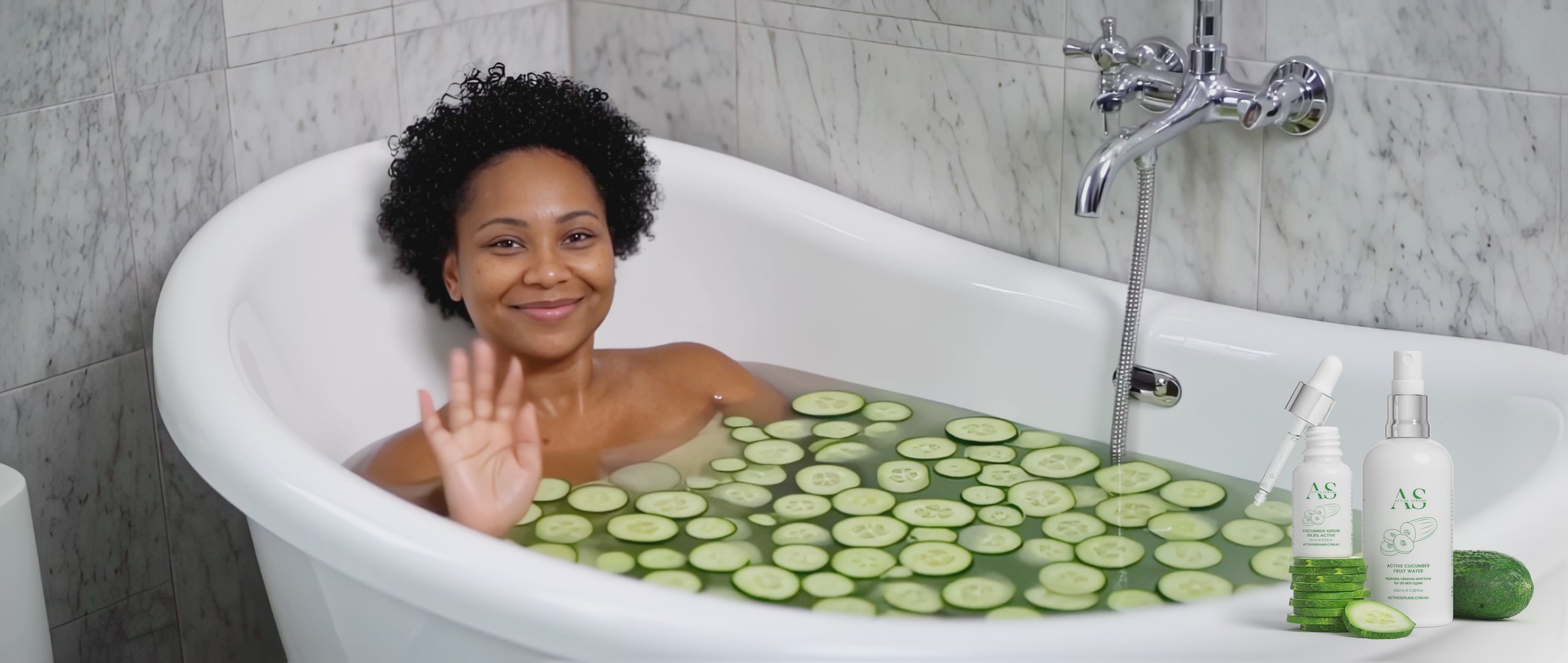 Active Cucumber Duo skincare set featured with a woman in a bath filled with fresh cucumber slices.